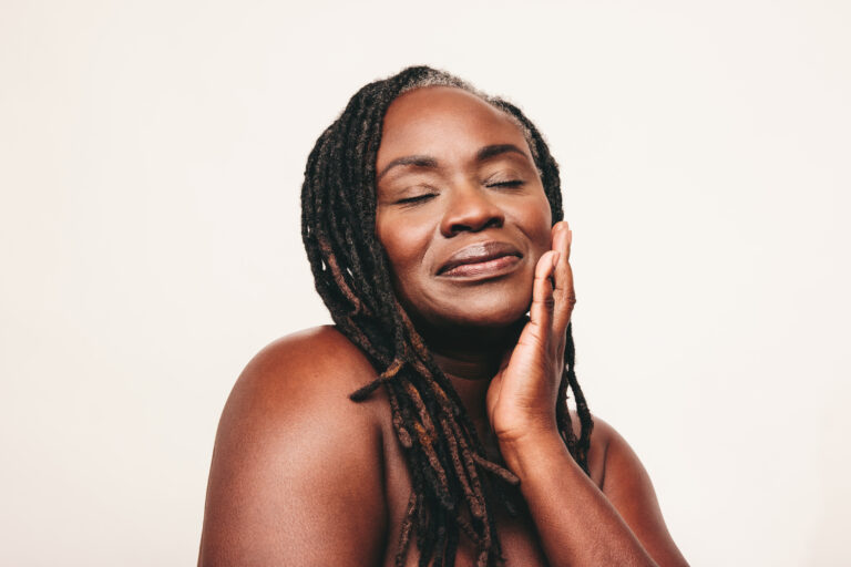 Smiling woman after Xeomin vs Botox treatment with smoother forehead and crow’s feet reduction