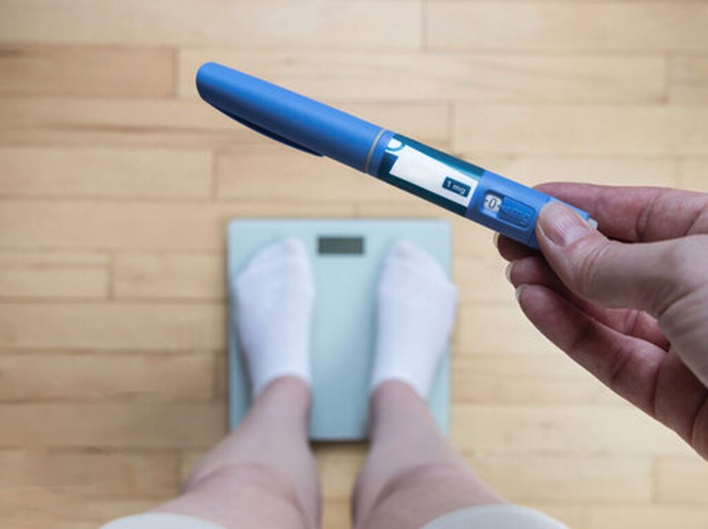 Woman holding semaglutide injection pen for medical weight loss treatment