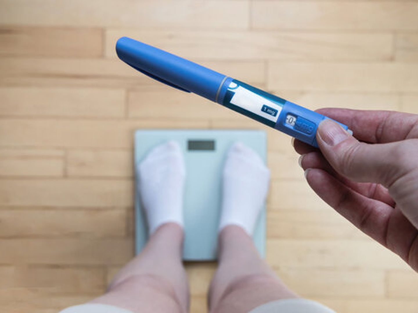 Woman holding semaglutide injection pen for medical weight loss treatment