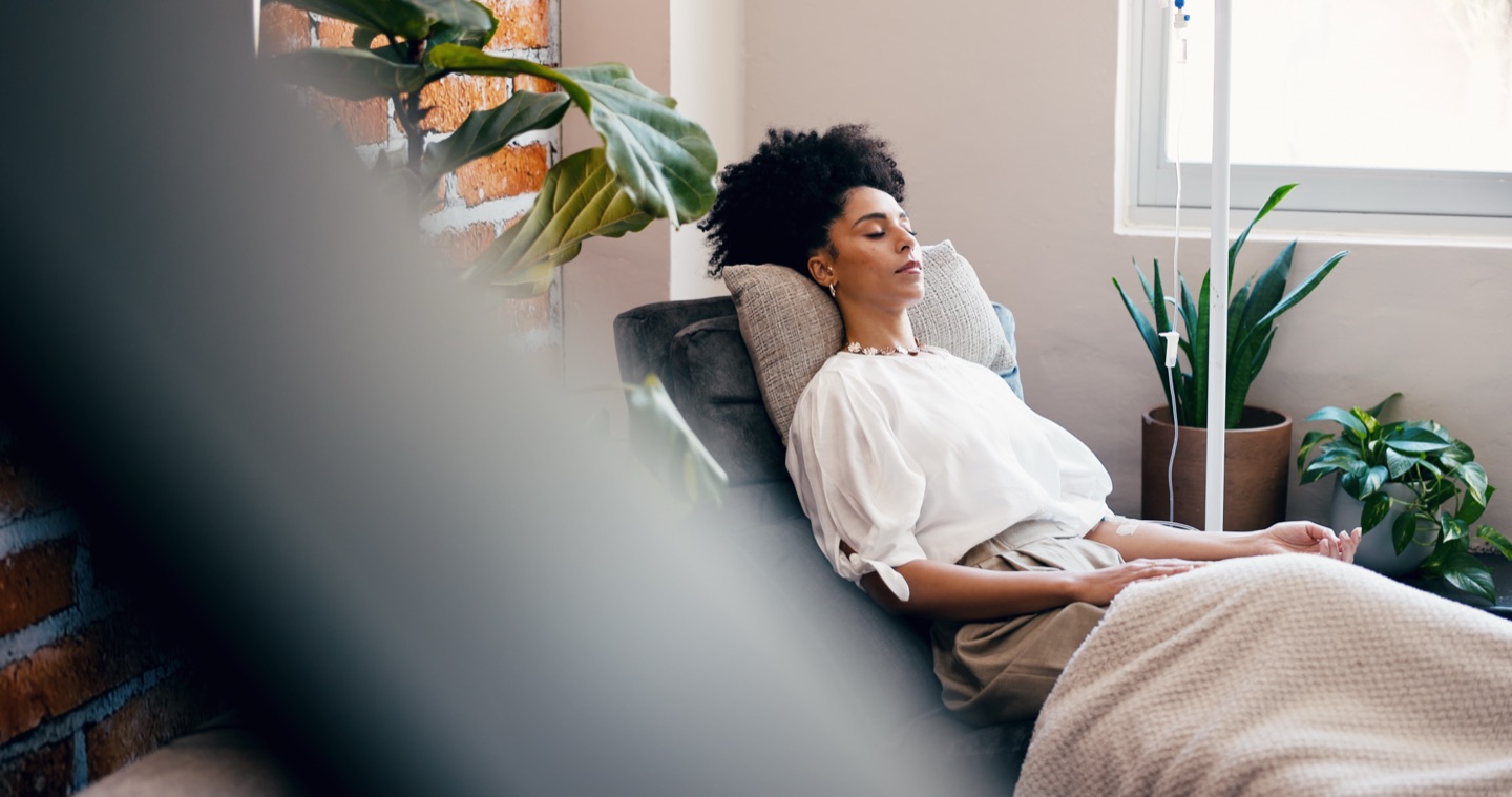 Woman relaxing in a lounge chair during an IV vitamin drip session